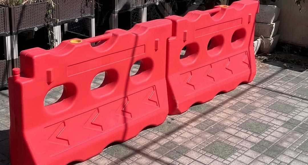 Foto produk realistis road barrier HDPE Karpinus dalam kondisi kosong, dengan tampilan jelas pada lubang pengisian, bentuk bodi, kaki penopang, serta sistem sambungan. Gunakan bentuk asli produk sebagai referensi.